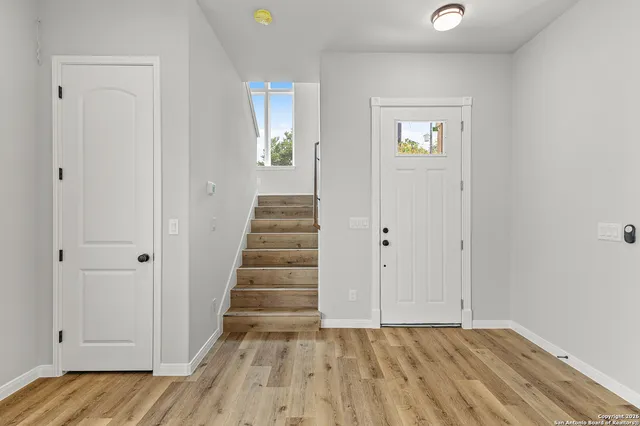 a view of a hallway with wooden floor and closet area