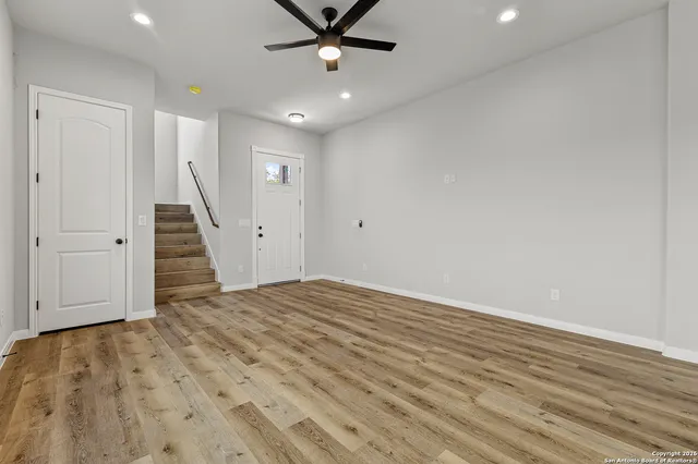 an empty room with wooden floor and entryway