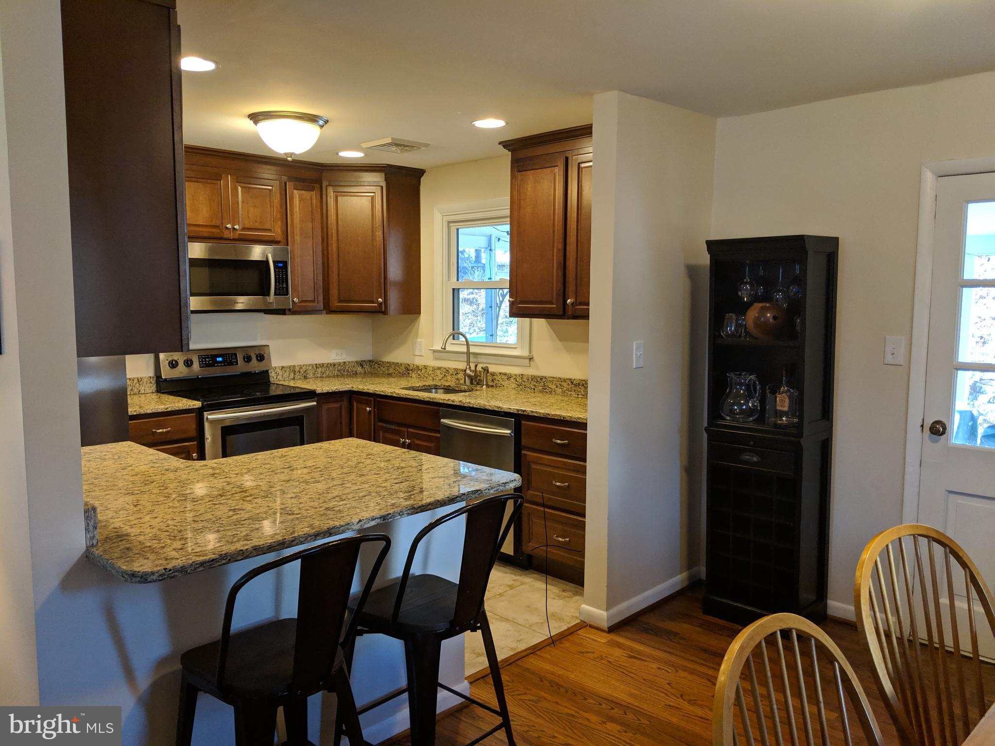 116 Bartholomew Road Berwyn, PA 19312 - Photo 2 of 24 a kitchen with stainless steel appliances granite countertop a kitchen island a table and chairs