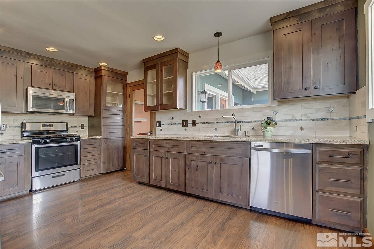 3830 West 7th Street Reno, NV 89503 - Photo 1 of 1 a kitchen with stainless steel appliances granite countertop a stove a sink dishwasher and a microwave oven with wooden floor