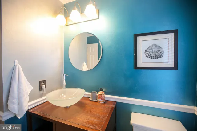 a bathroom with a sink mirror and a toilet