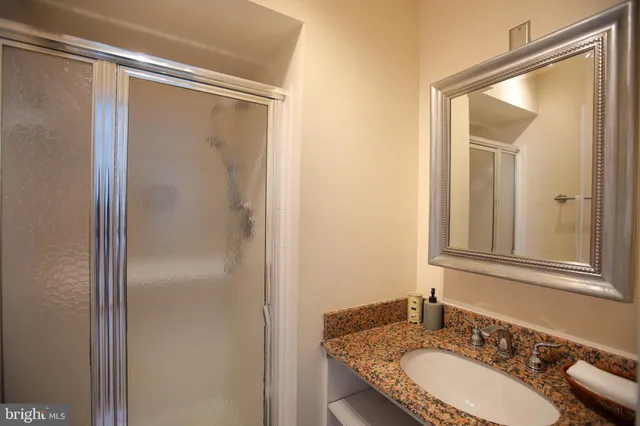a bathroom with a granite countertop sink mirror and a
