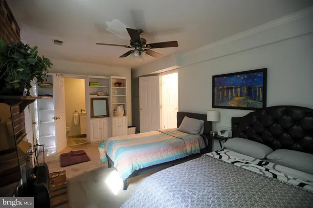 a spacious bedroom with a bed a couch and a potted plant