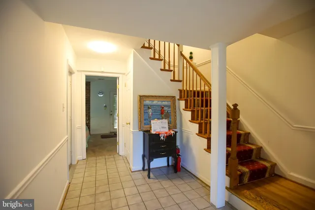 a view of a hallway to a livingroom with furniture and stairs