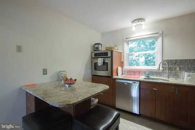 a kitchen with a sink a microwave and wooden floor