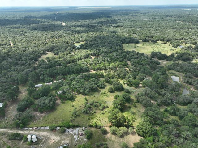 an aerial view of residential houses with outdoor space and trees
