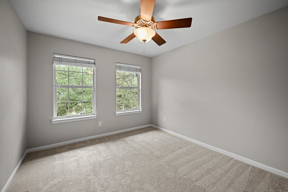 2823 Lantana Ridge Drive Austin, TX 78732 - Photo 25 of 34 an empty room with windows and fan