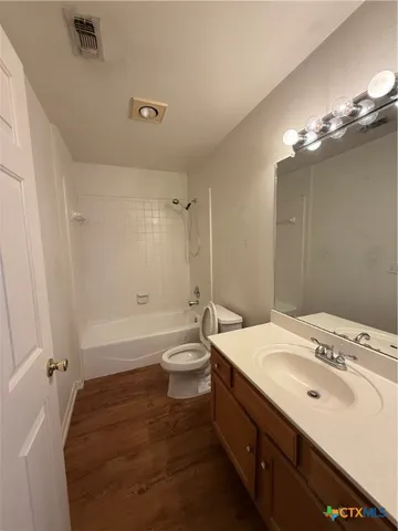 a bathroom with a sink a toilet a mirror and shower