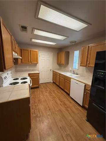 a kitchen with stainless steel appliances granite countertop a stove a sink dishwasher and a refrigerator