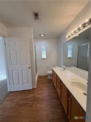 a spacious bathroom with a double vanity sink and a mirror