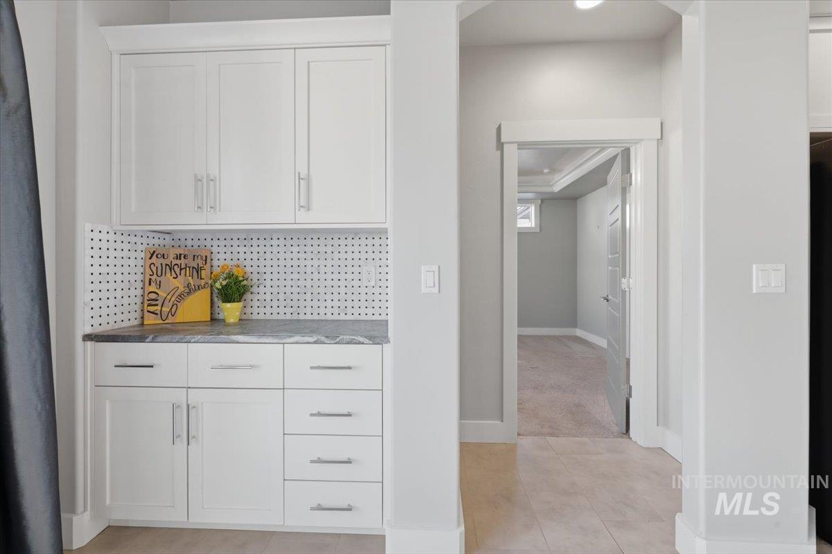 15381 Silver Oak Way Caldwell, ID 83607 - Photo 13 of 48 Bar with white cabinets, light tile patterned flooring, decorative backsplash, and dark stone countertops