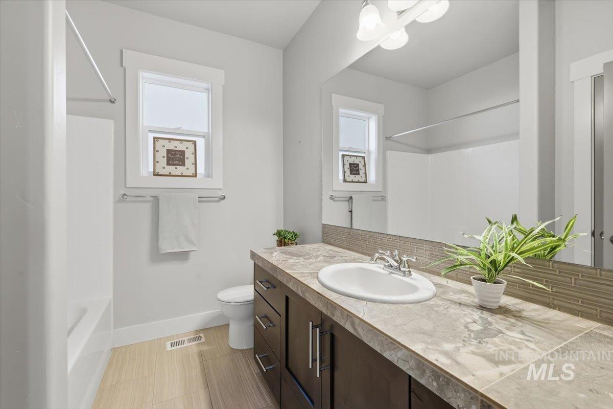 15381 Silver Oak Way Caldwell, ID 83607 - Photo 34 of 48 Bathroom with vanity, decorative backsplash, healthy amount of natural light, and a chandelier