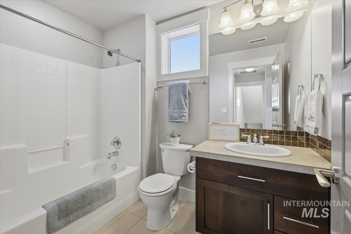 15381 Silver Oak Way Caldwell, ID 83607 - Photo 39 of 48 Full bath featuring vanity, bathing tub / shower combination, backsplash, and light tile patterned flooring