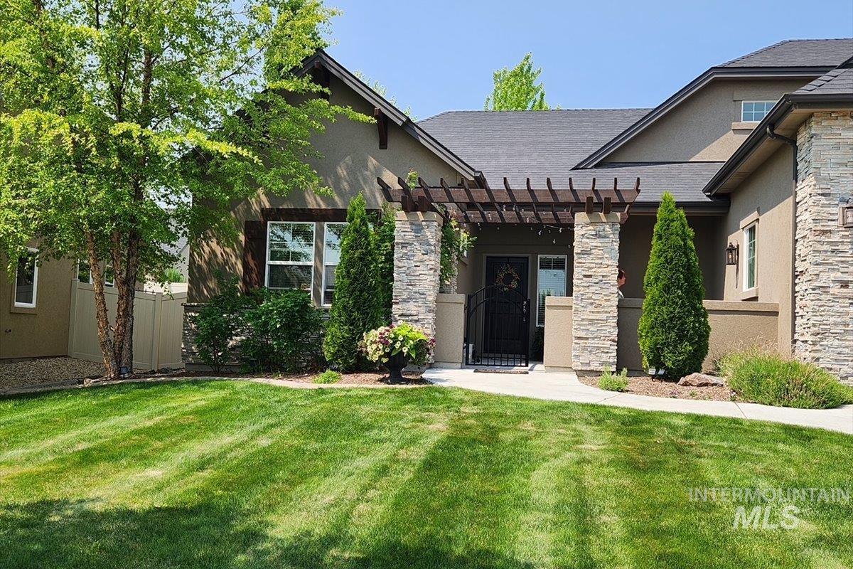 15381 Silver Oak Way Caldwell, ID 83607 - Photo 46 of 48 View of front of property featuring a pergola, stucco siding, stone siding, a patio, and a shingled roof
