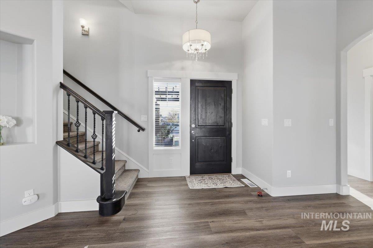 15381 Silver Oak Way Caldwell, ID 83607 - Photo 6 of 48 Entryway with dark wood finished floors, hanging lights, and a high ceiling