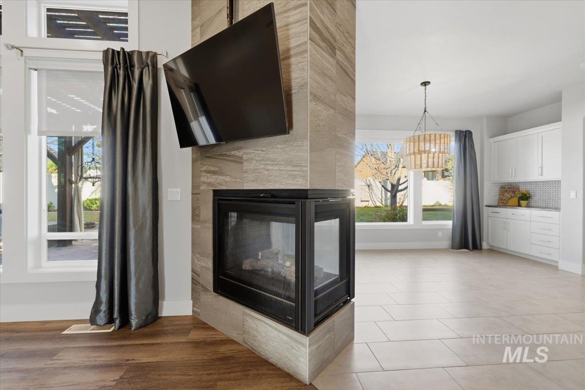 15381 Silver Oak Way Caldwell, ID 83607 - Photo 10 of 48 Unfurnished living room featuring a tiled fireplace and a chandelier