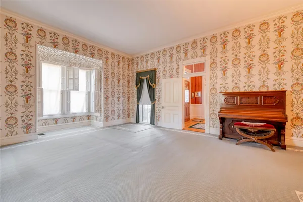 a view of an empty room with a fireplace and a window