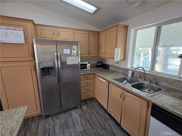 a kitchen with a refrigerator sink and cabinets