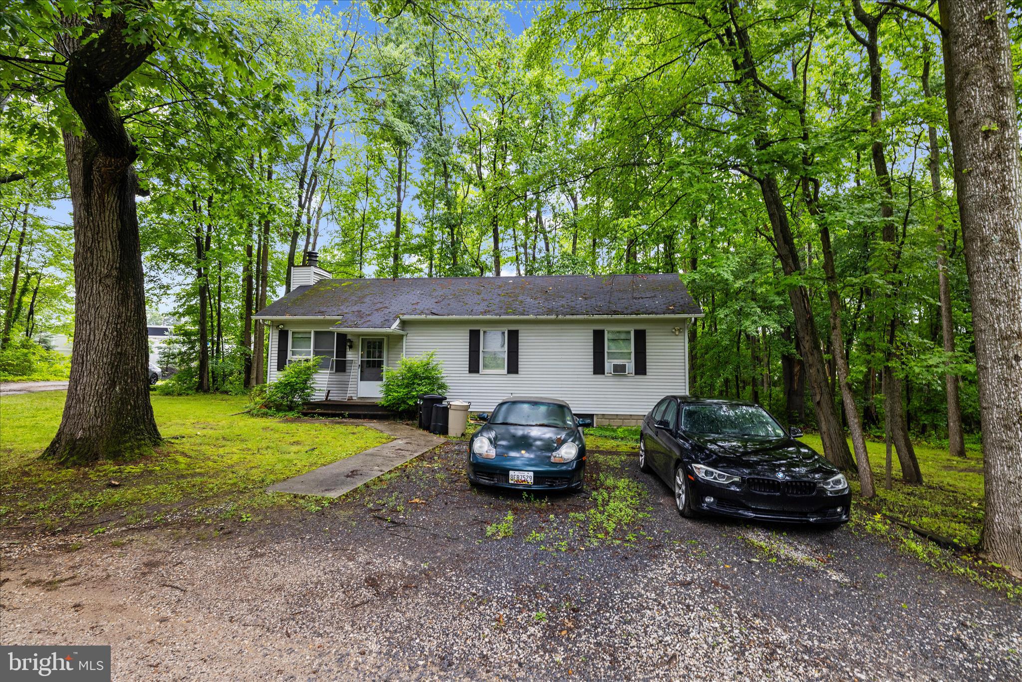 a front view of a house with a garden and trees