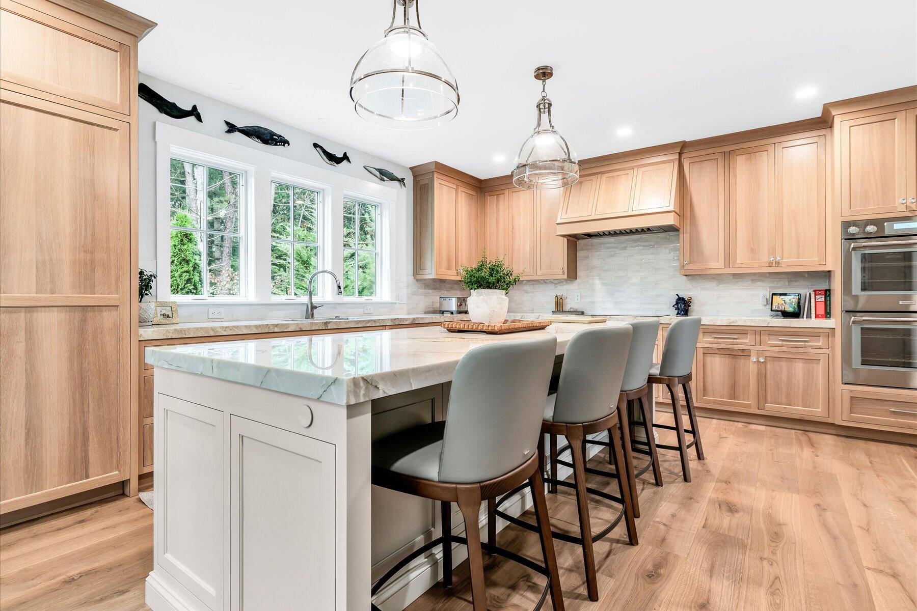 14 Willow Circle Mashpee, MA 02649 - Photo 33 of 60 a kitchen with stainless steel appliances granite countertop a stove a refrigerator a sink dishwasher a dining table and chairs with wooden floor