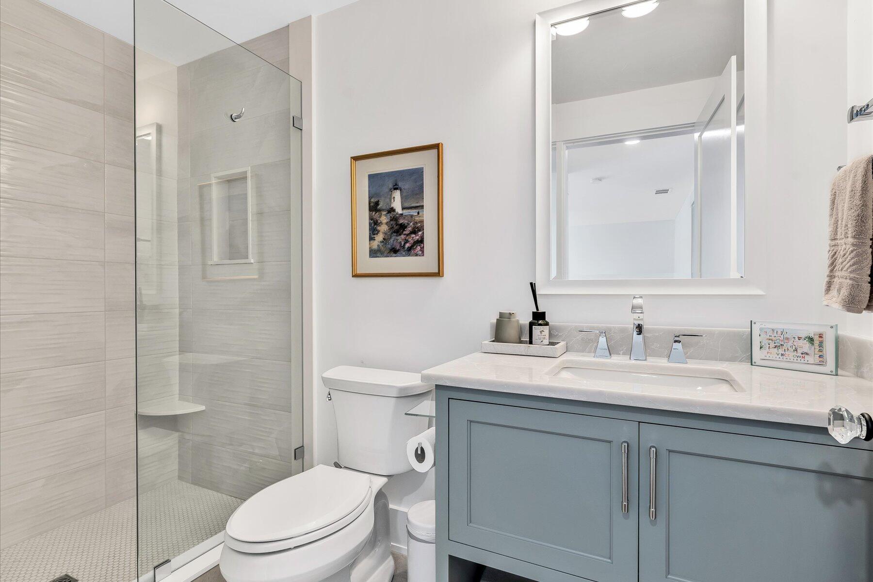 14 Willow Circle Mashpee, MA 02649 - Photo 55 of 60 a bathroom with a toilet a sink a mirror and shower