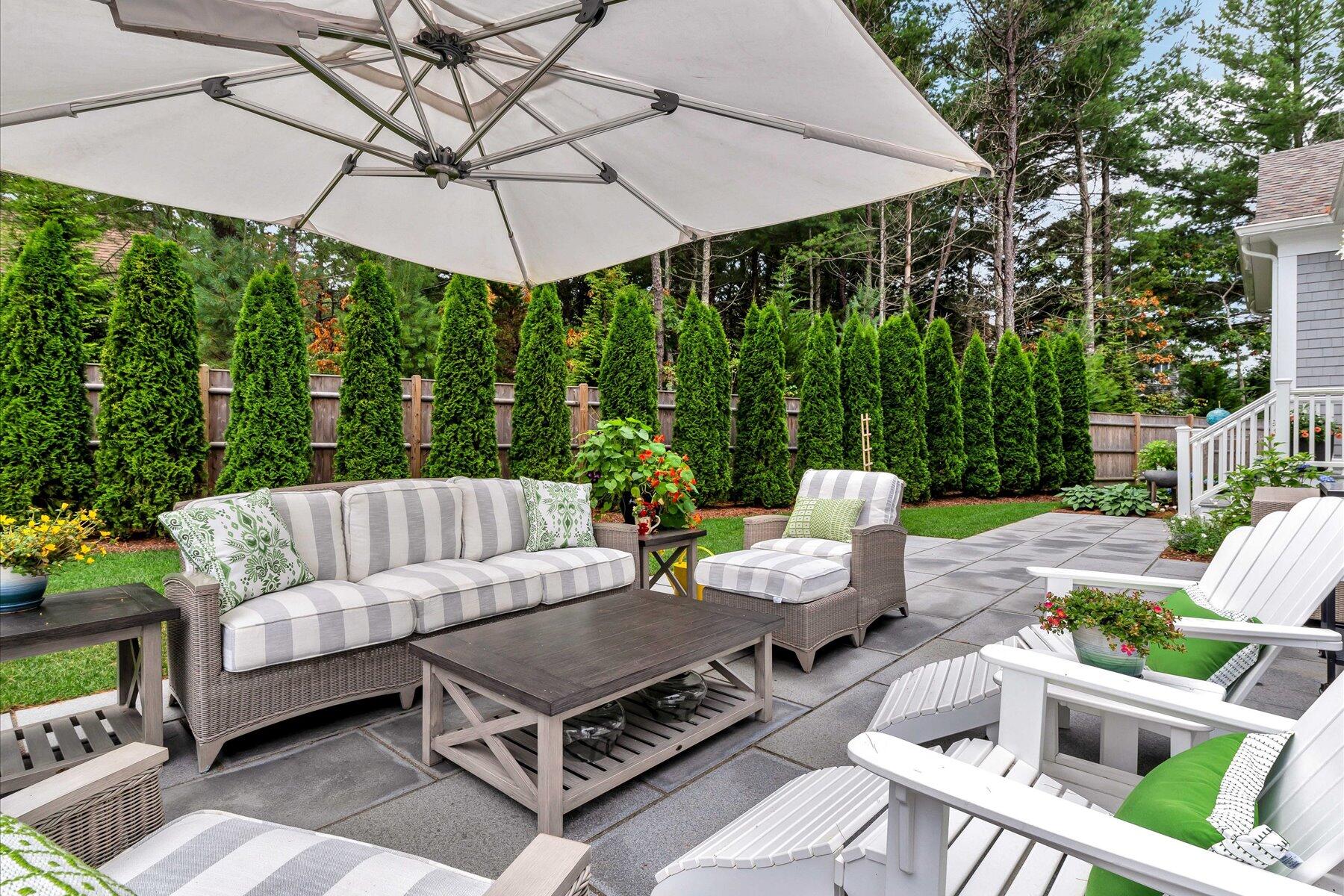 14 Willow Circle Mashpee, MA 02649 - Photo 10 of 60 a view of a patio with a table and chairs under an umbrella
