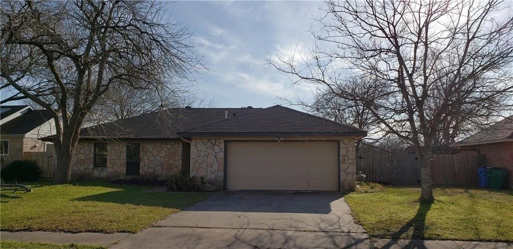 a front view of a house with a yard and trees