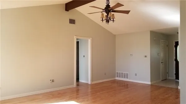 an empty room with closet and a chandelier fan