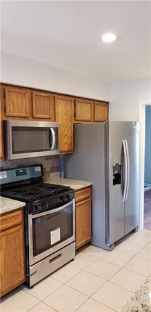 a kitchen with granite countertop white cabinets and stainless steel appliances