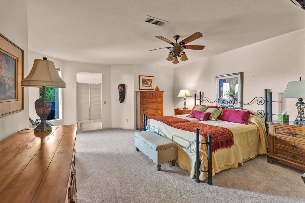 202 Pointing Rock Drive, Unit 4 Borrego Springs, CA 92004 - Photo 8 of 27 a spacious bedroom with a bed a chandelier and closet