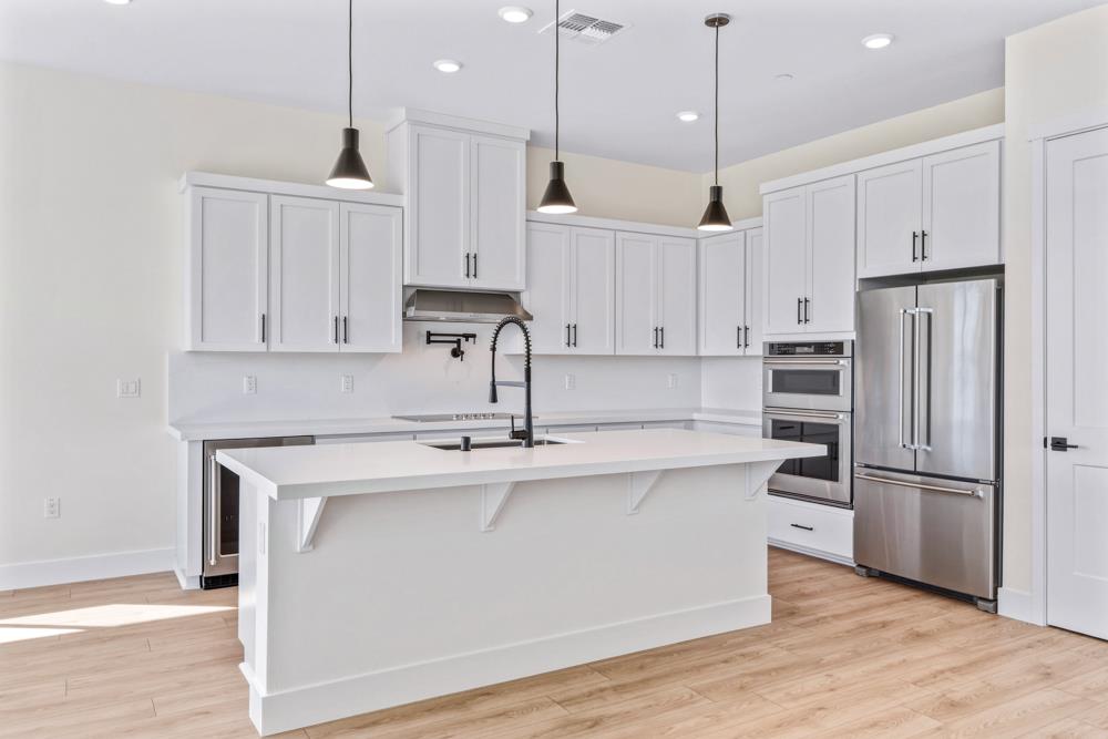 14834 Grace Warren Way Rancho Murieta, CA 95683 - Photo 11 of 18 a kitchen with kitchen island white cabinets and stainless steel appliances