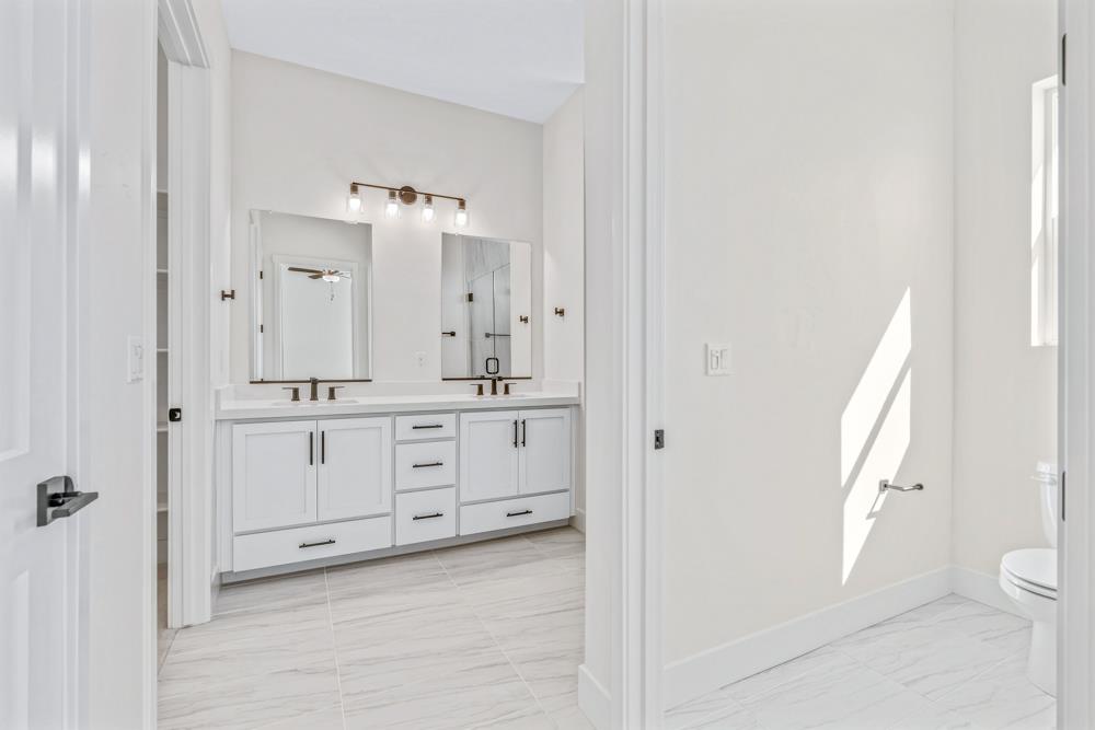 14834 Grace Warren Way Rancho Murieta, CA 95683 - Photo 15 of 18 a spacious bathroom with a double vanity sink a toilet and a mirror