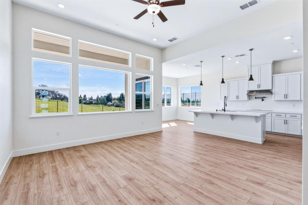14834 Grace Warren Way Rancho Murieta, CA 95683 - Photo 3 of 18 a large kitchen with stainless steel appliances granite countertop a stove a sink dishwasher a microwave oven and white cabinets with wooden floor
