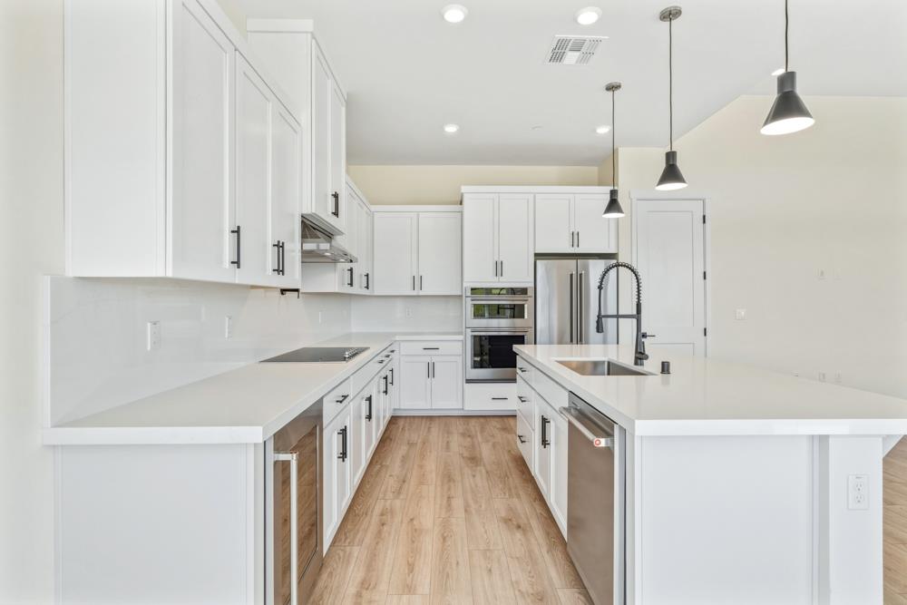 14834 Grace Warren Way Rancho Murieta, CA 95683 - Photo 7 of 18 a kitchen with white cabinets appliances and sink