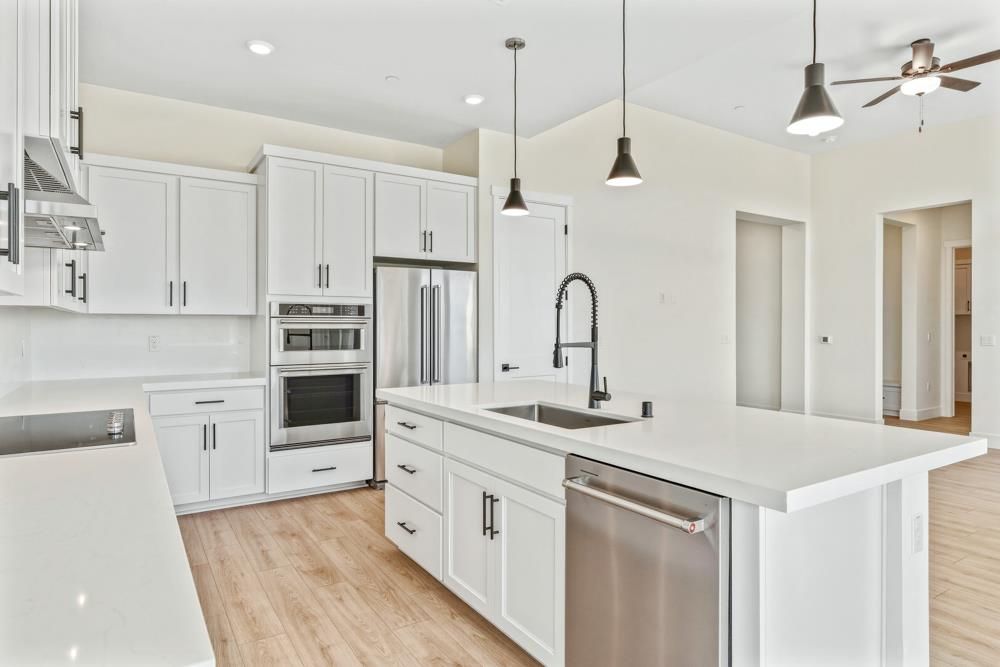 14834 Grace Warren Way Rancho Murieta, CA 95683 - Photo 9 of 21 a kitchen with white cabinets and white appliances