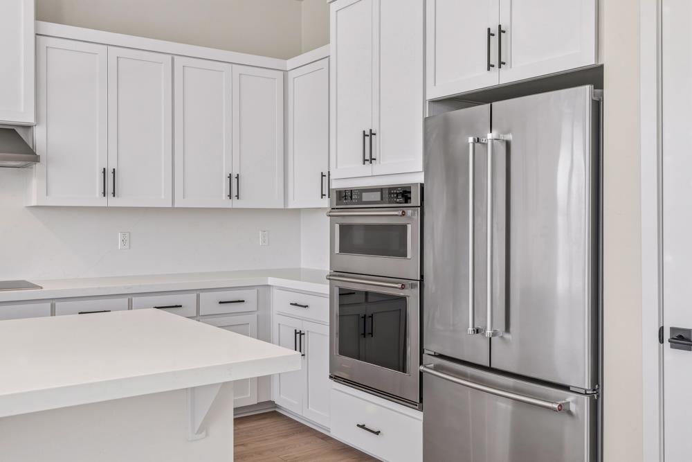 14834 Grace Warren Way Rancho Murieta, CA 95683 - Photo 10 of 18 a kitchen with white cabinets and stainless steel appliances