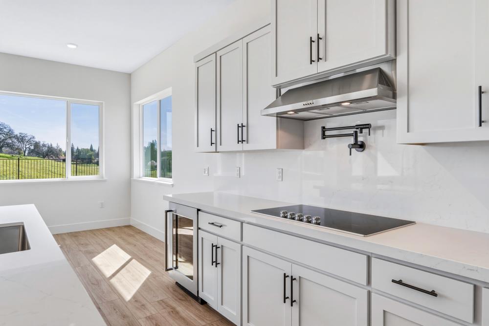 14834 Grace Warren Way Rancho Murieta, CA 95683 - Photo 10 of 21 a kitchen with stainless steel appliances granite countertop a sink and cabinets with wooden floor
