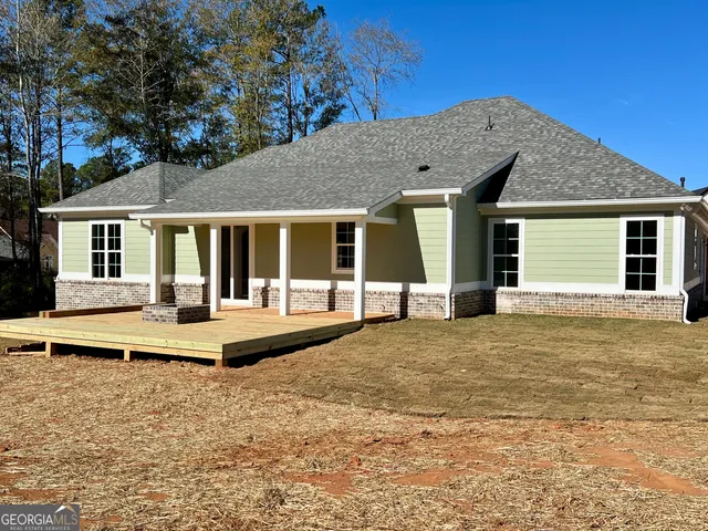 a front view of house with yard and trees in the background