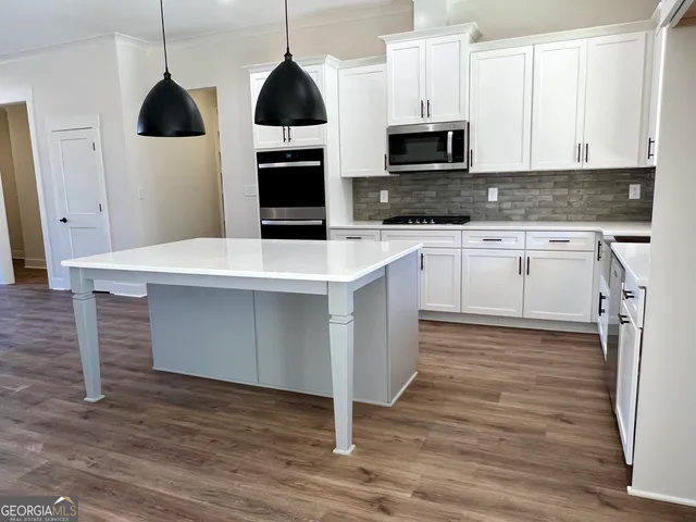 a view of empty room with wooden floor and windows