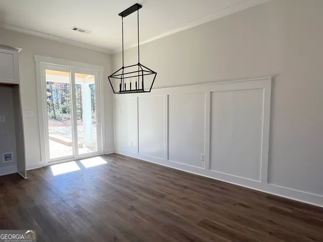 an empty room with wooden floor and stairs