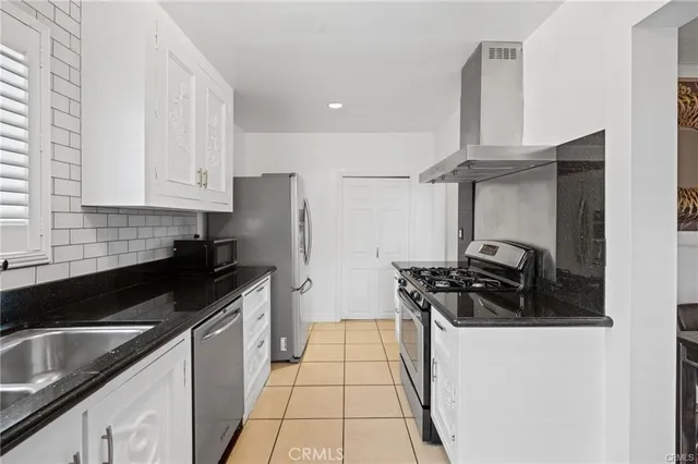 a kitchen with stainless steel appliances a stove a sink a refrigerator and cabinets
