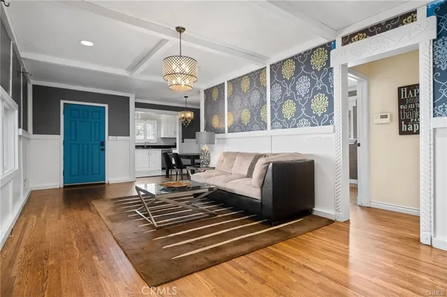 a living room with stainless steel appliances granite countertop furniture rug and wooden floor