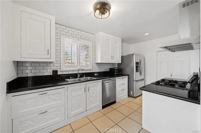 a kitchen with granite countertop a stove a sink and a refrigerator
