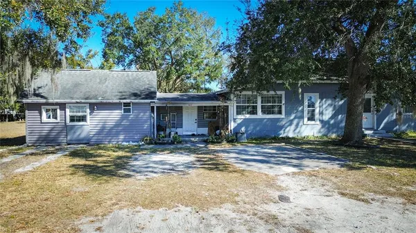 a view of a house with backyard and trees