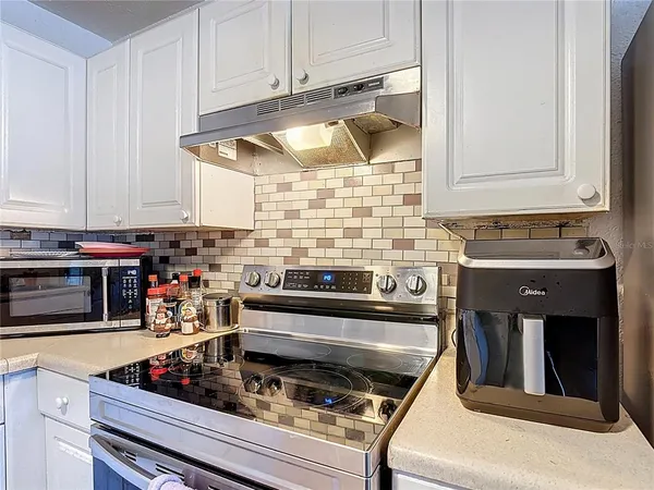 a kitchen with stainless steel appliances granite countertop a stove and a microwave