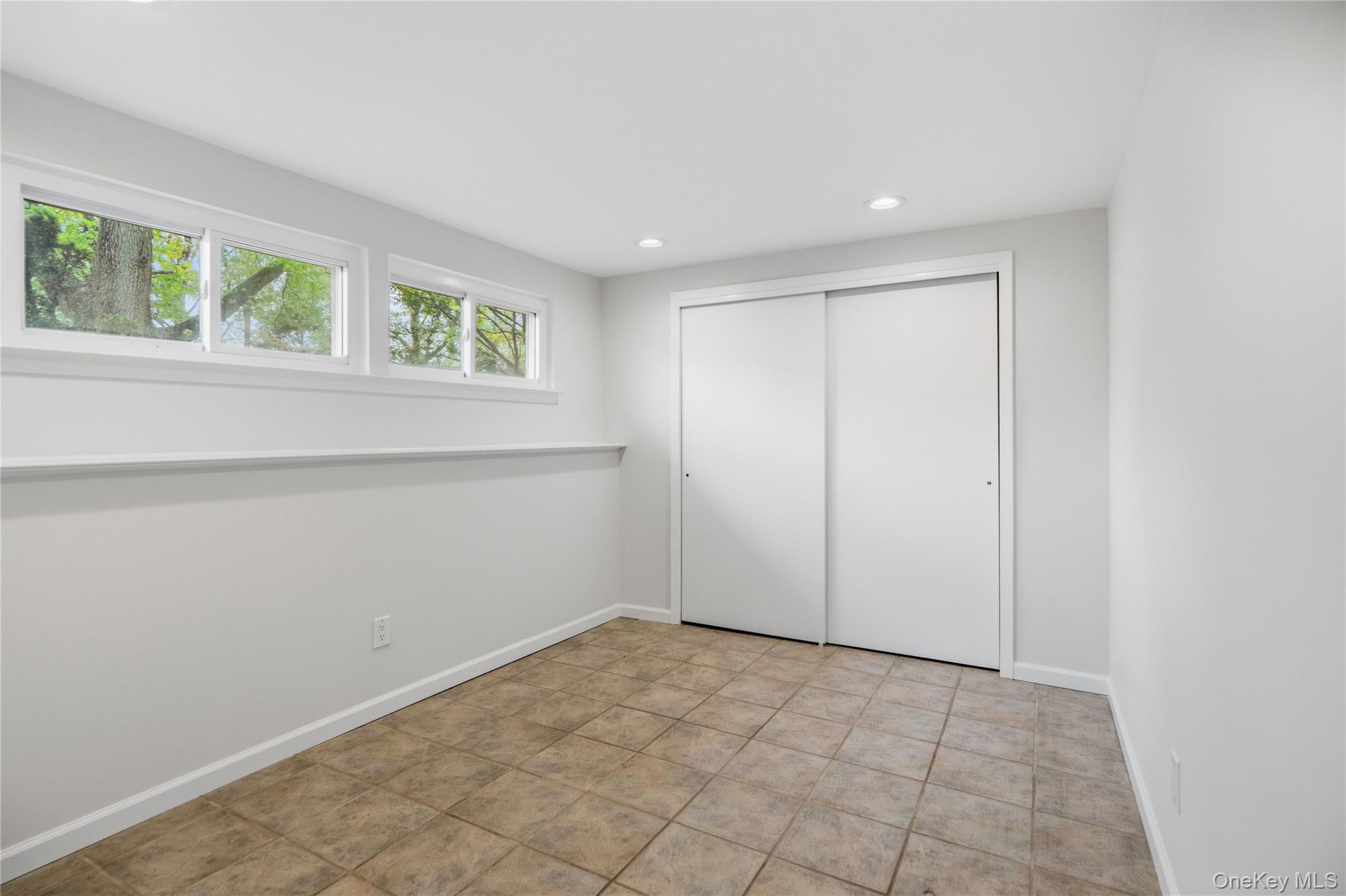 183 North Marginal Road Jericho, NY 11753 - Photo 23 of 28 First Floor Bedroom/Office featuring light gray walls, transom windows, recessed lighting, and tile flooring