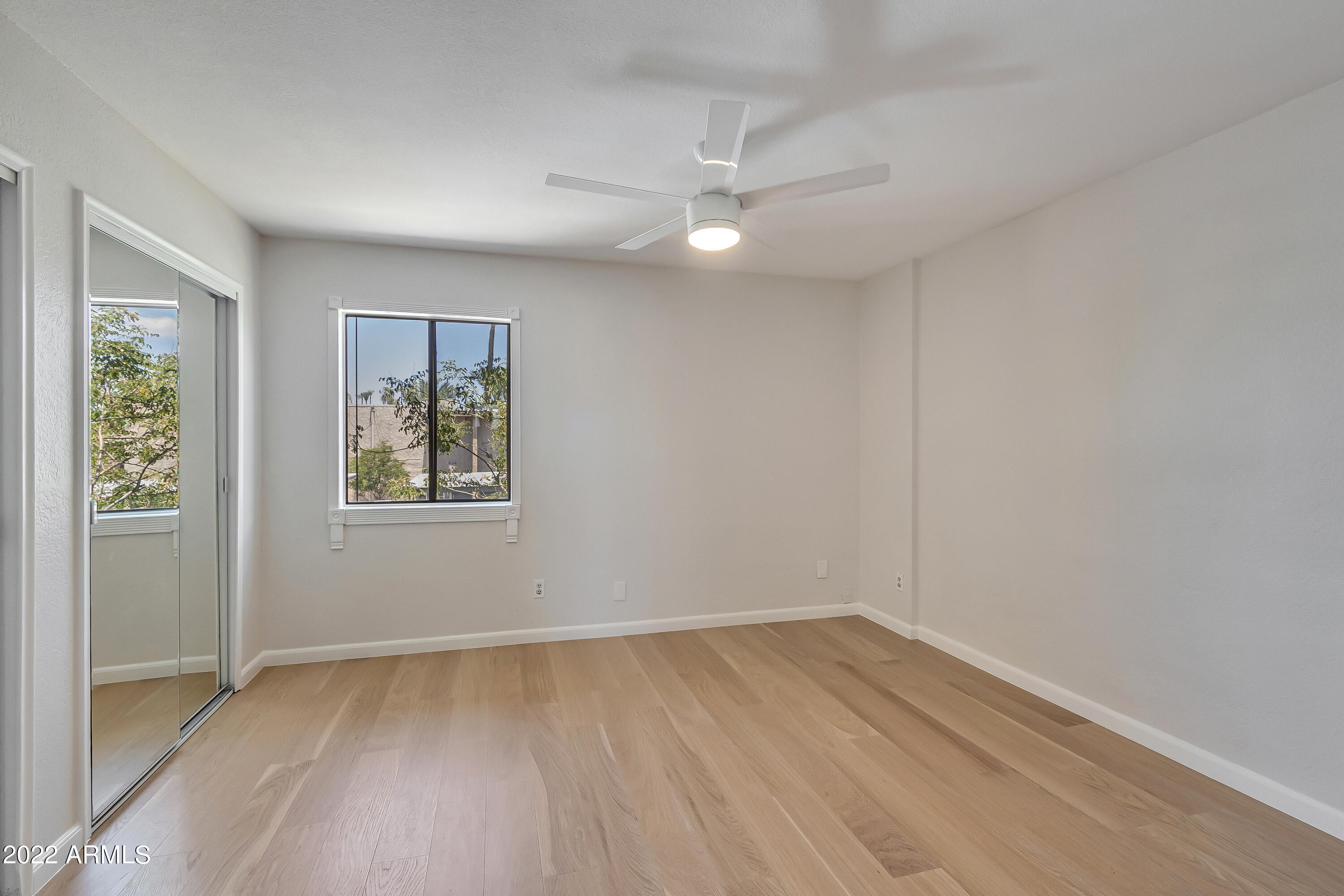 6348 North 7th Avenue, Unit 12 Phoenix, AZ 85013 - Photo 13 of 22 an empty room with wooden floor and windows