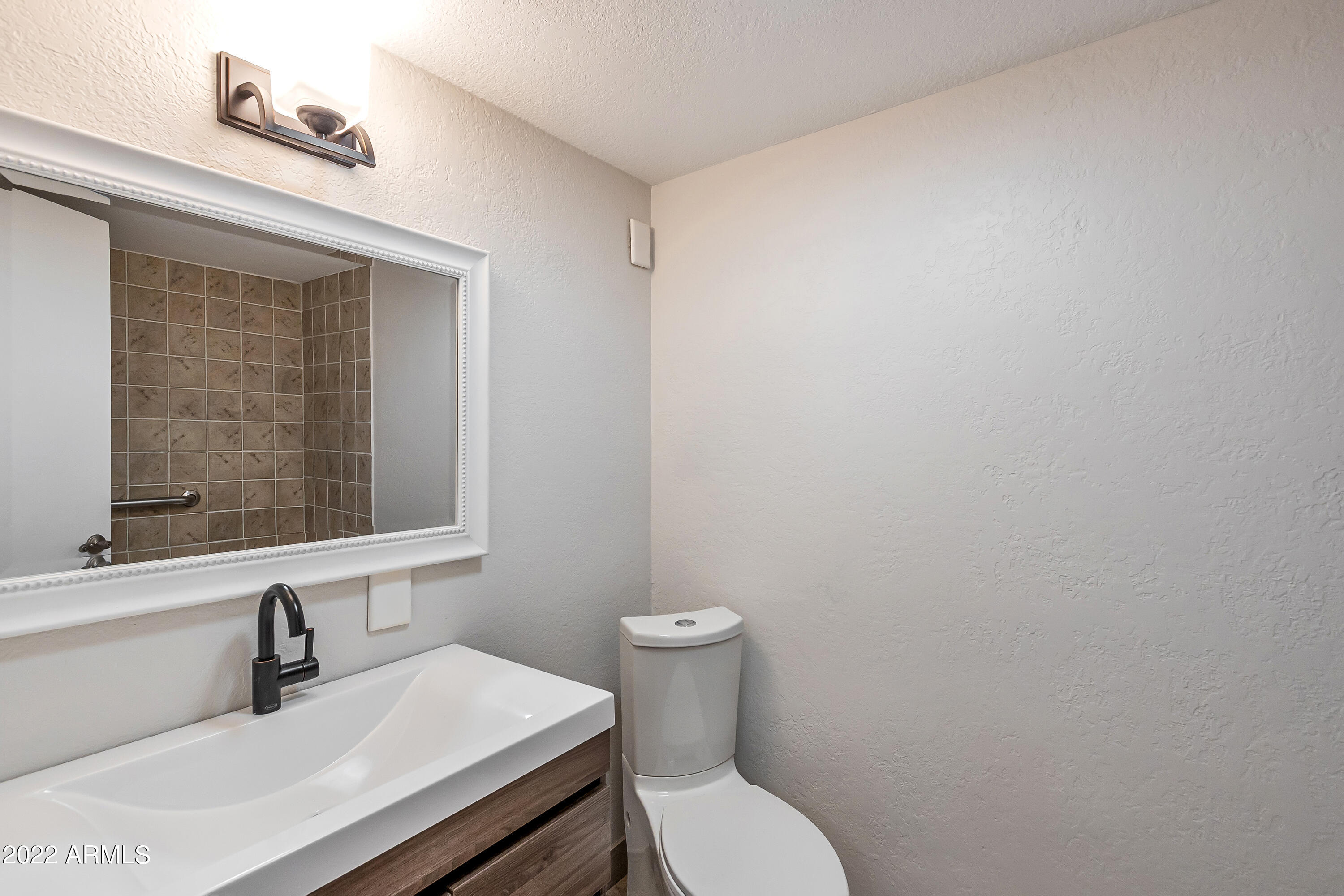 6348 North 7th Avenue, Unit 12 Phoenix, AZ 85013 - Photo 18 of 22 a bathroom with a sink a toilet and a window