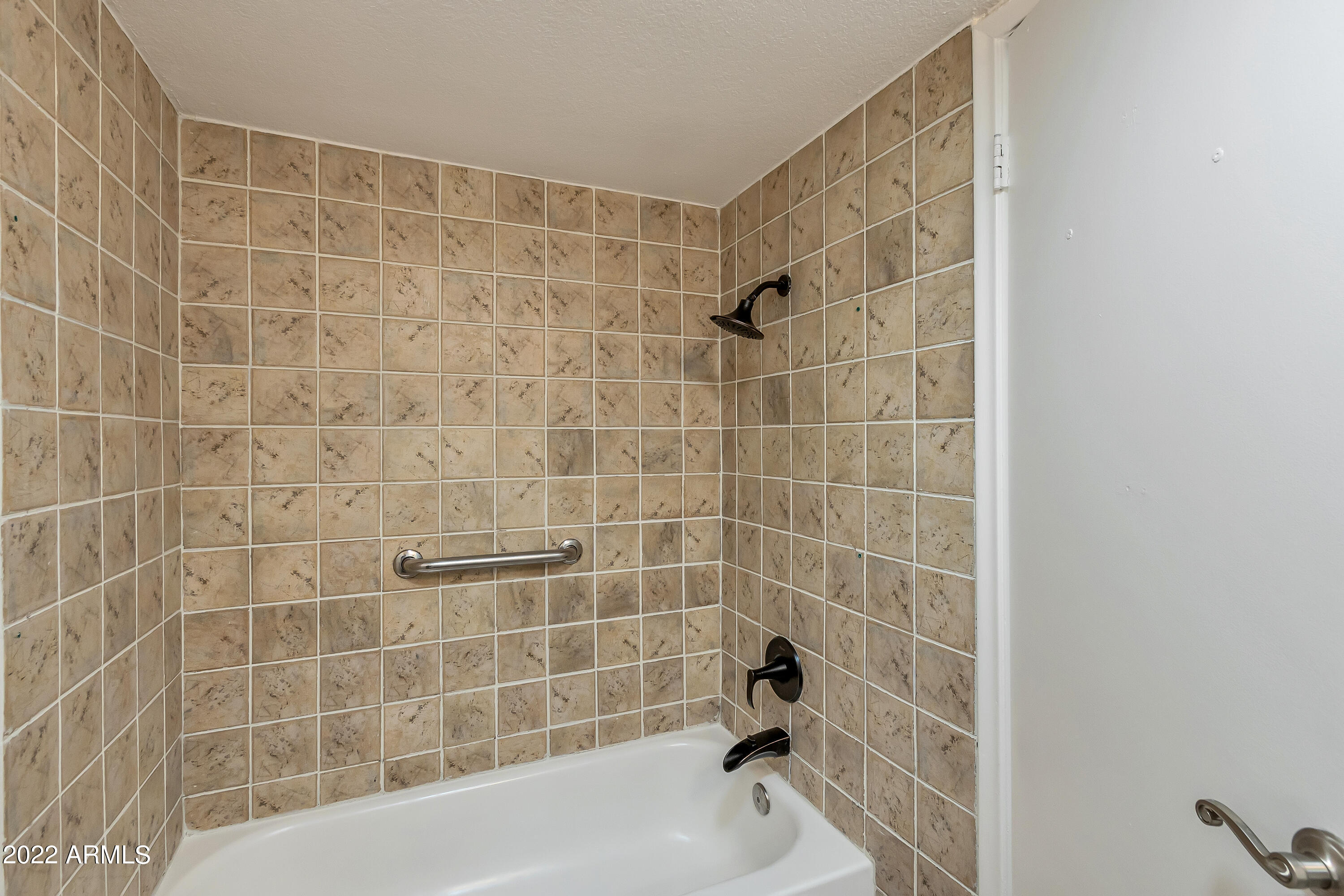 6348 North 7th Avenue, Unit 12 Phoenix, AZ 85013 - Photo 19 of 22 a bathroom with a shower and a bathtub