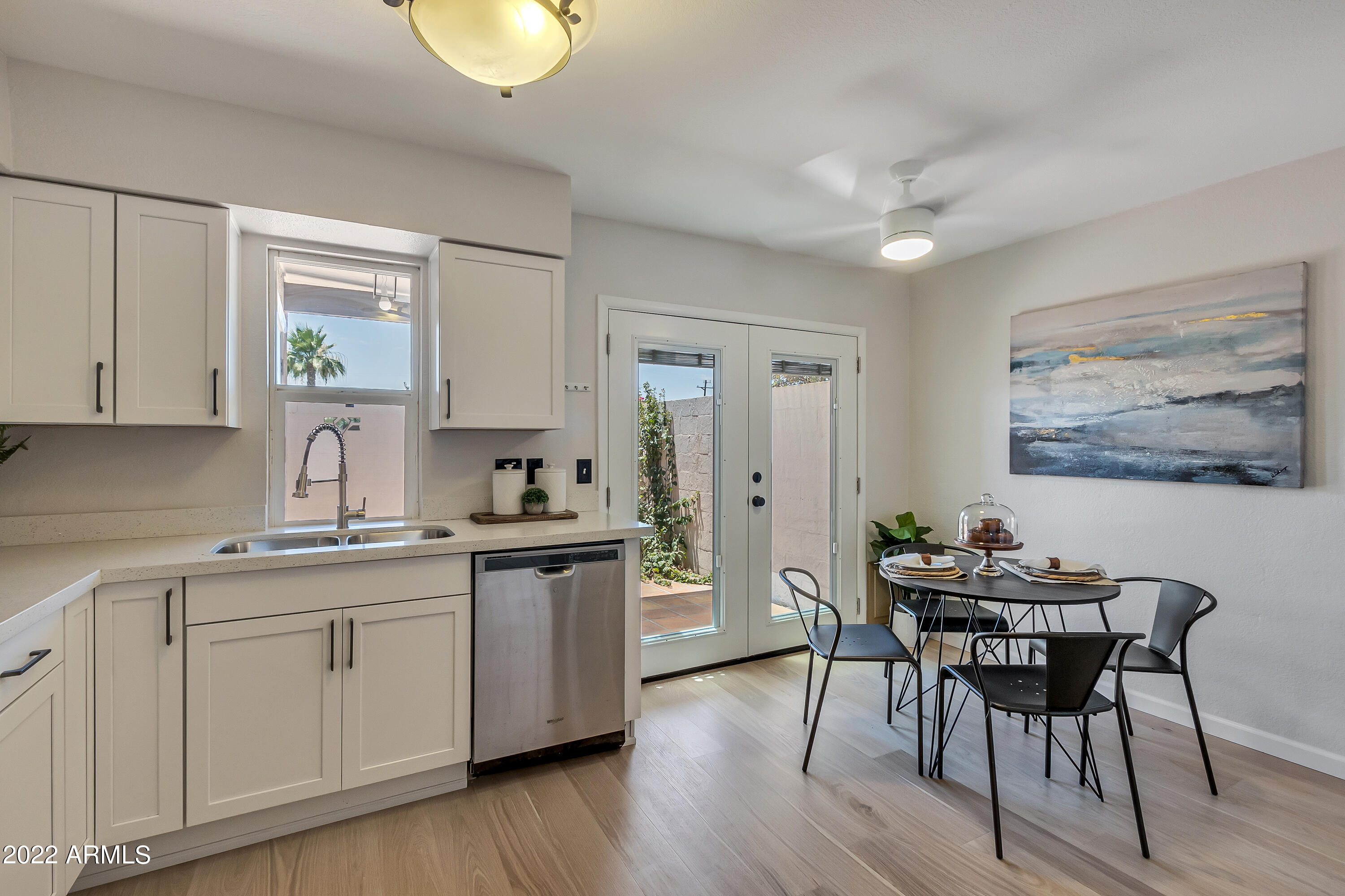 6348 North 7th Avenue, Unit 12 Phoenix, AZ 85013 - Photo 6 of 22 a kitchen with stainless steel appliances granite countertop a stove a sink dishwasher a dining table and chairs with wooden floor